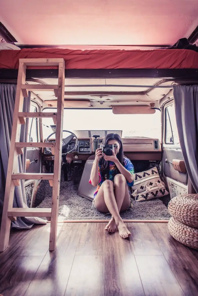 woman sitting in her RV below a bed