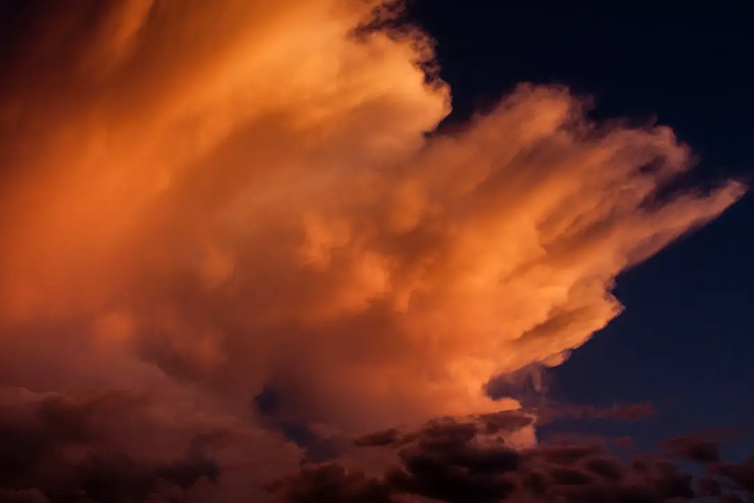 Wind blown cloud tops in the setting sun. 