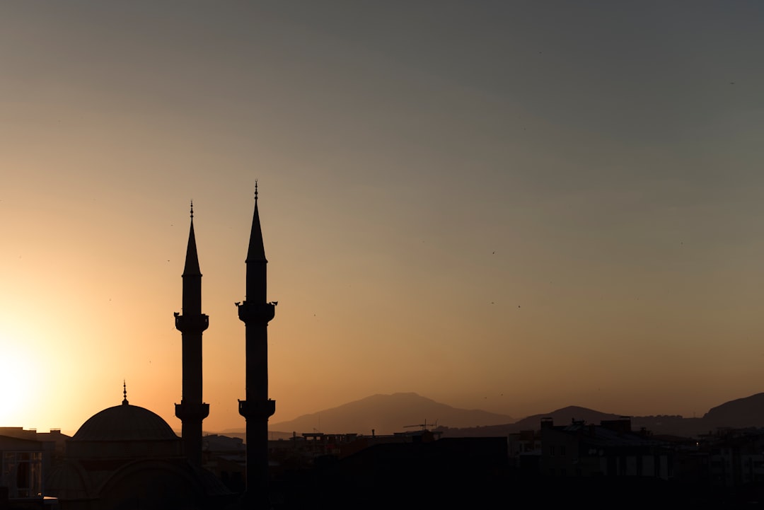 two mosque minarets under calm sky