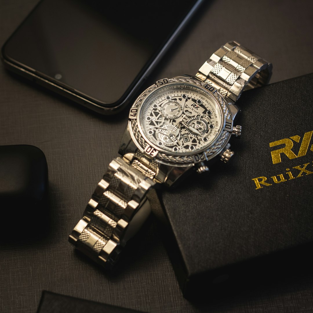 a watch sitting on top of a book next to a phone