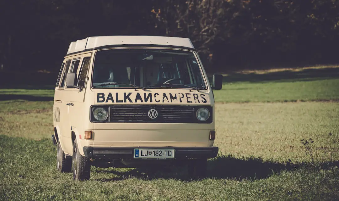 brown Volkswagen T3 camper van parked on grass field