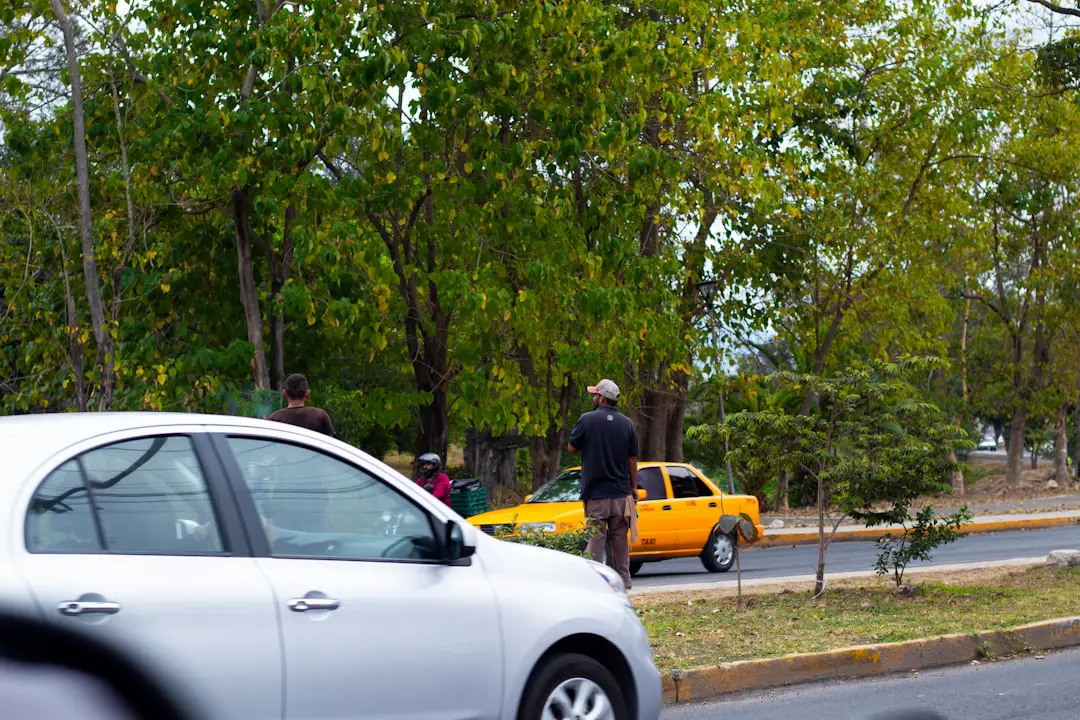 a man standing next to a white car on a street