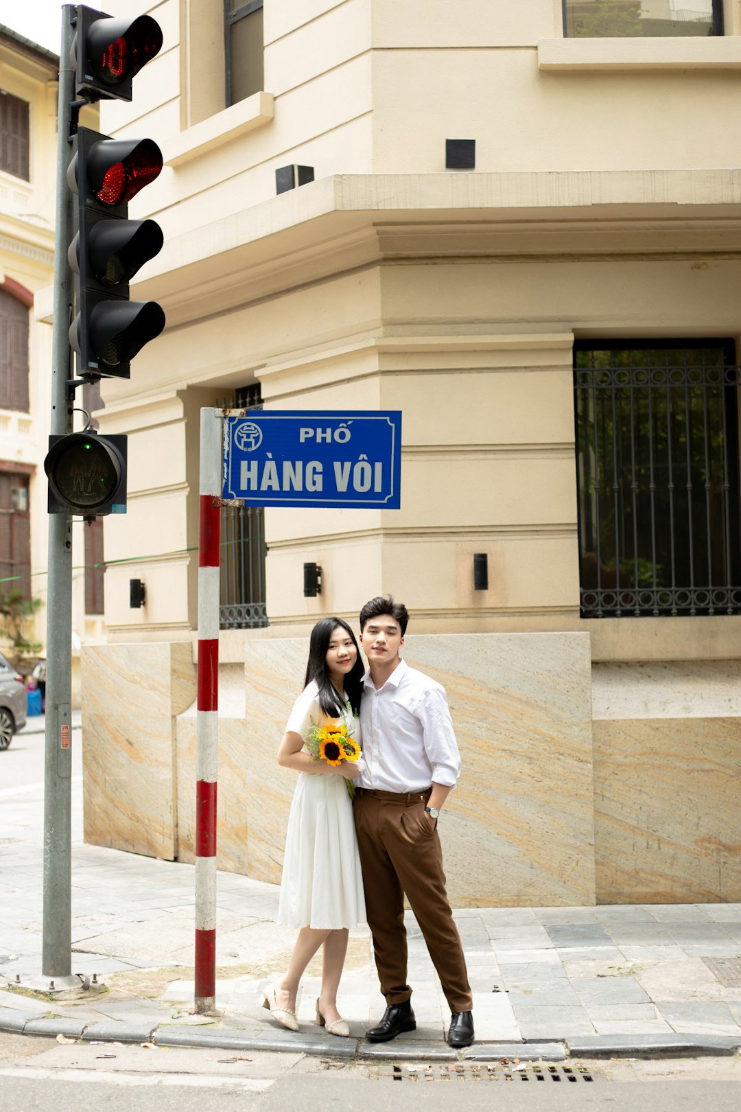 A man and a woman standing next to a traffic light